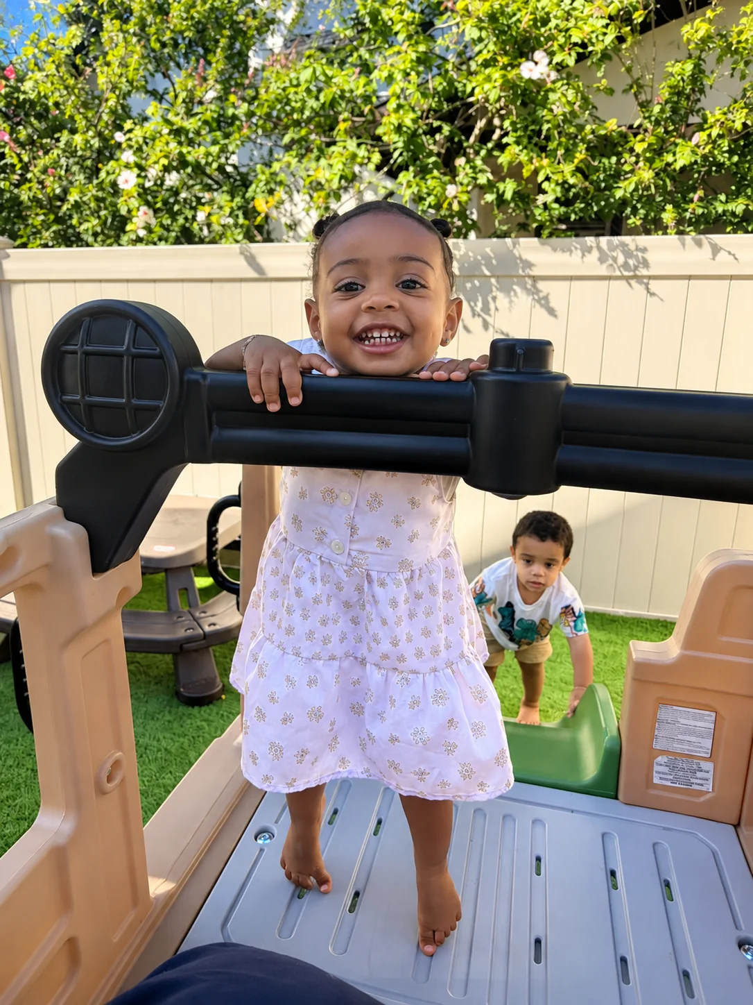Smiling toddler climbing on an outdoor play structure