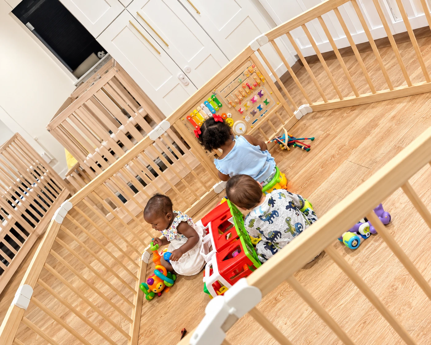 Children exploring colorful toys and sensory activities in a protected infant play area