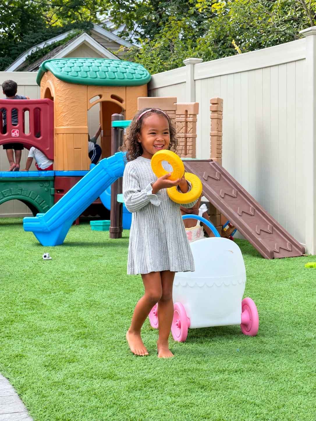 Smiling child holding bright rings during backyard play