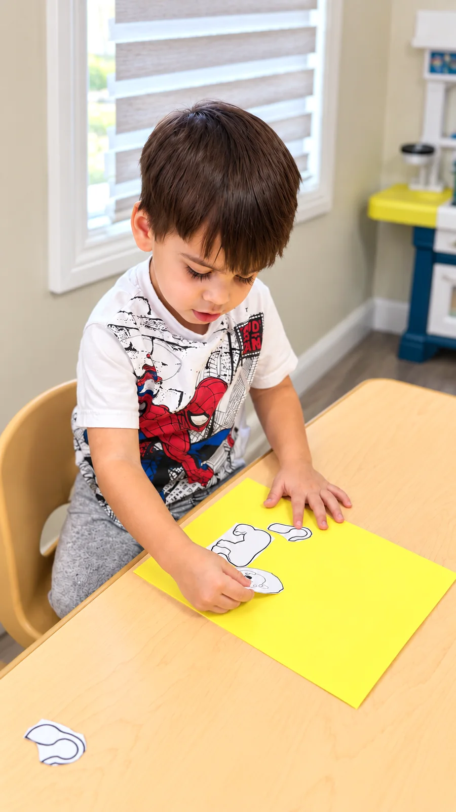 Preschool child completing a hands-on paper matching activity at a classroom table
