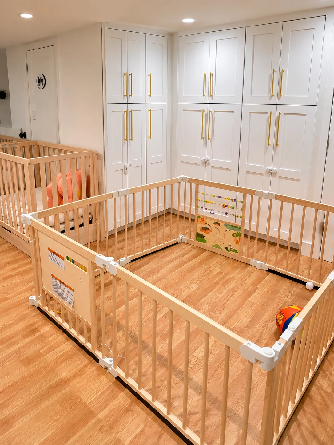 Spacious gated infant play area with natural wood rails, activity panels and secure storage