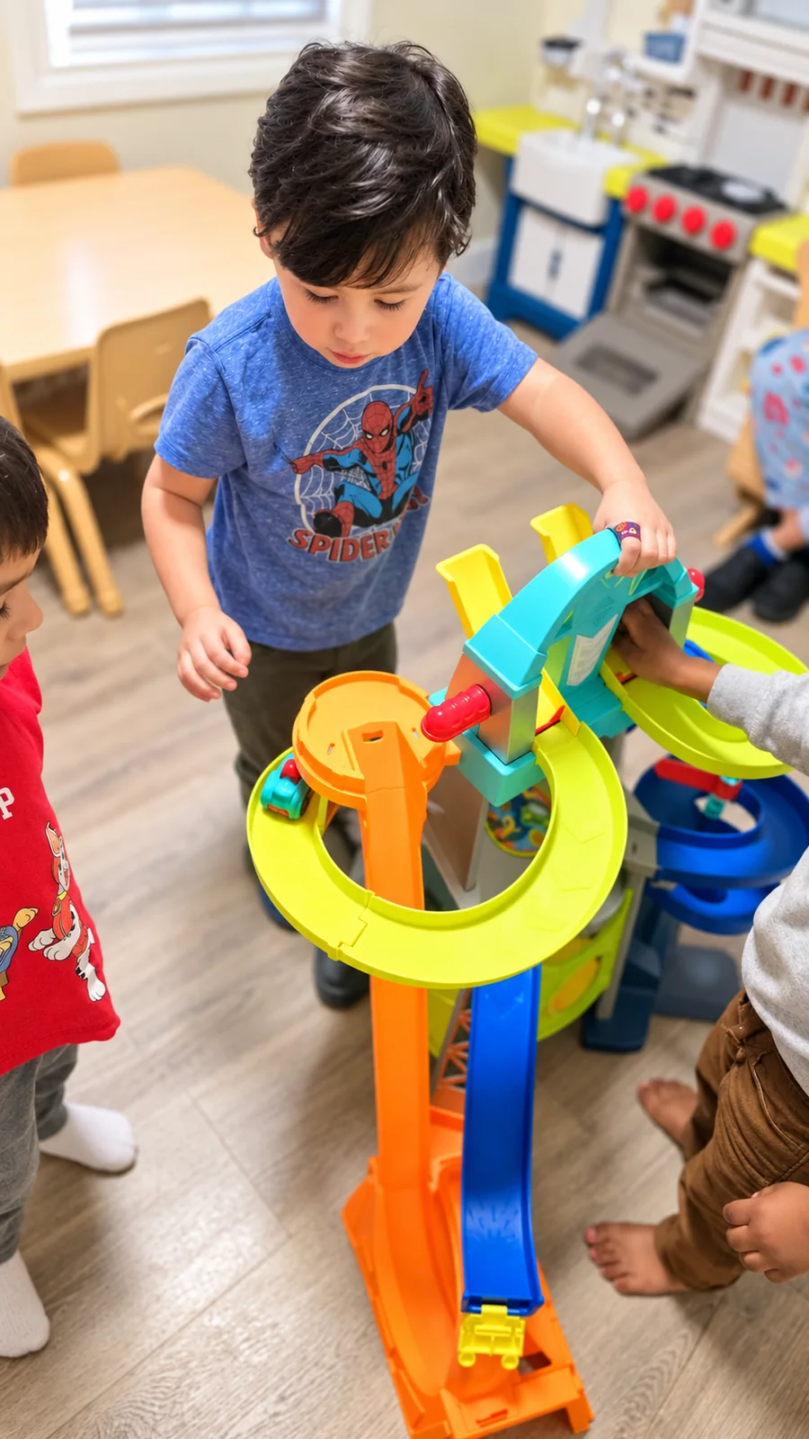 Children playing together with a colorful toy racetrack