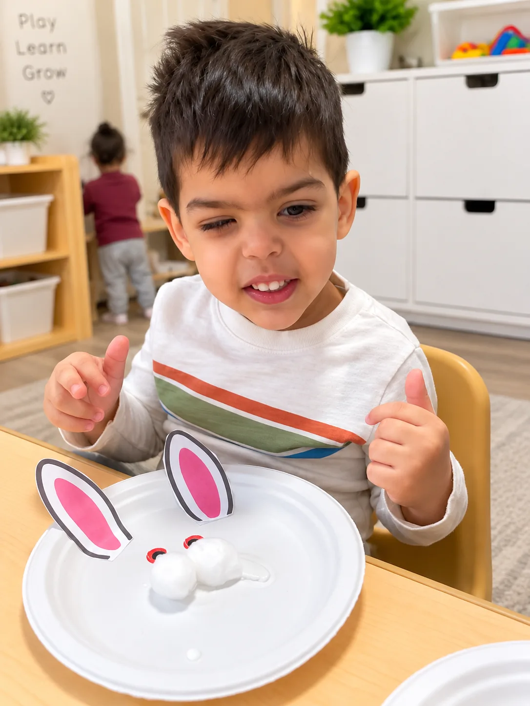 Smiling child showing a finished paper plate bunny craft with cotton ball details