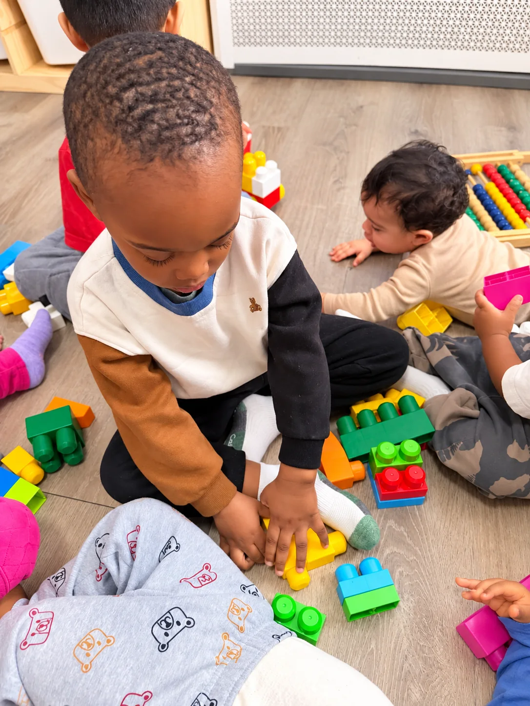 Children building and playing together with colorful blocks on the classroom floor