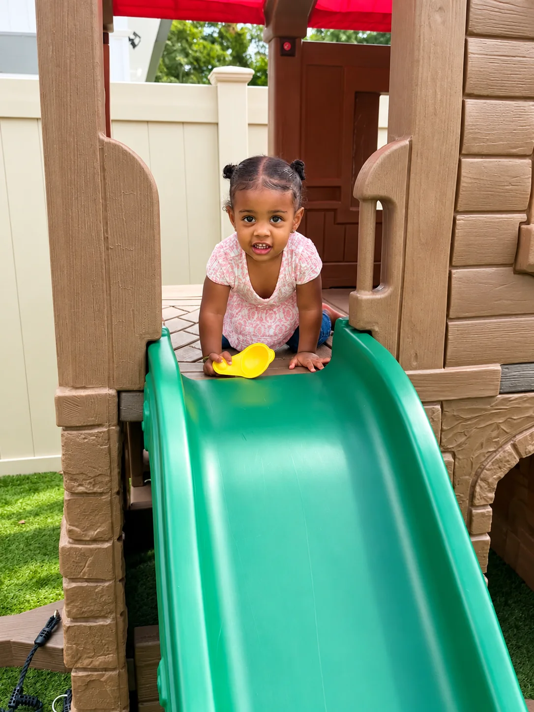 Toddler getting ready to slide down an outdoor play structure