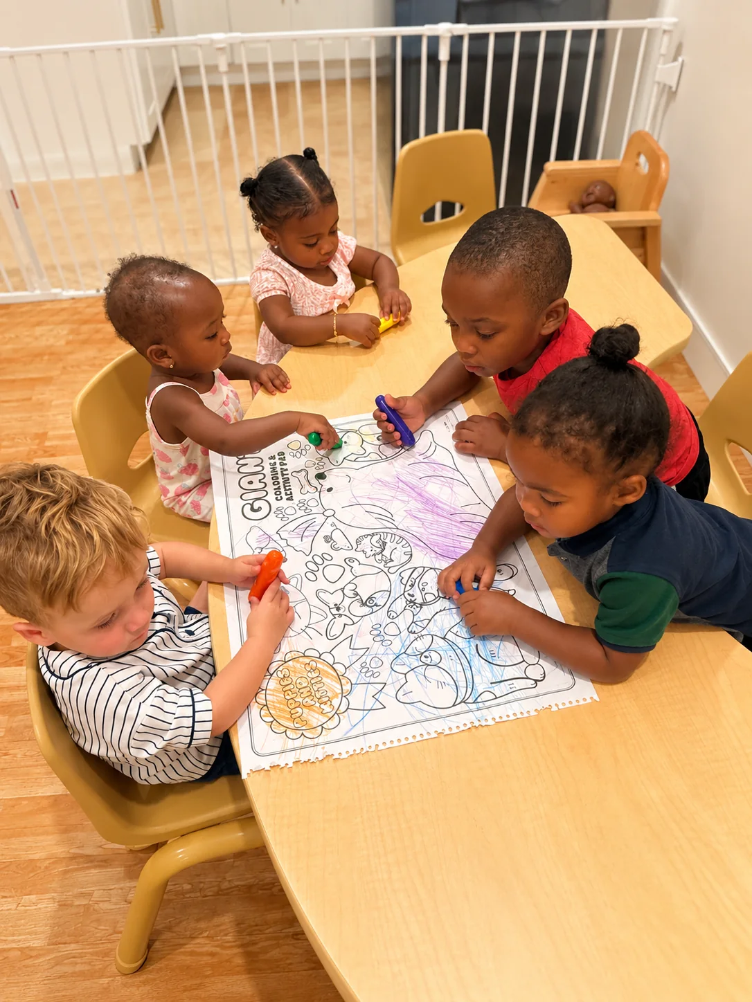 Five children gathered around a table for a shared coloring activity