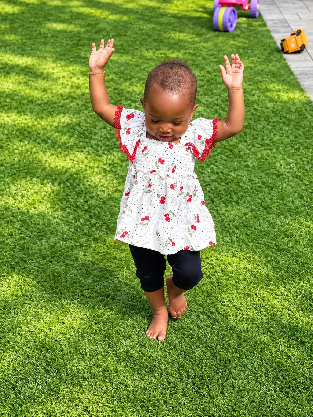Toddler moving joyfully across the outdoor play yard