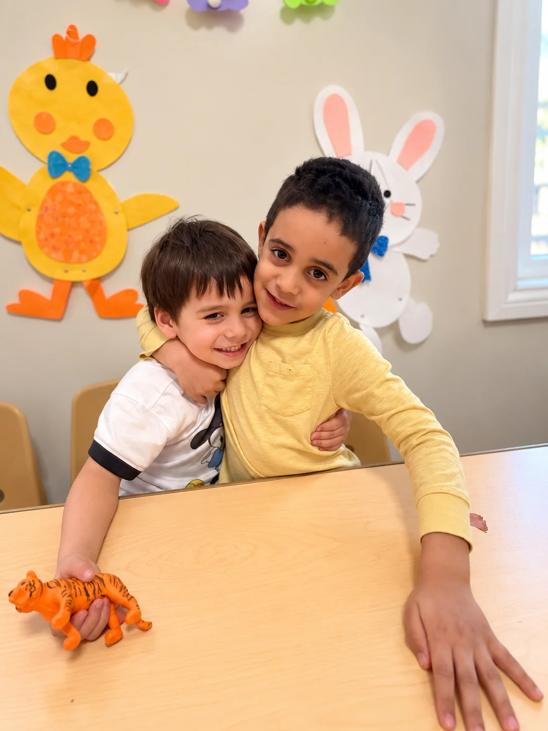 Two children sharing a warm hug during classroom play