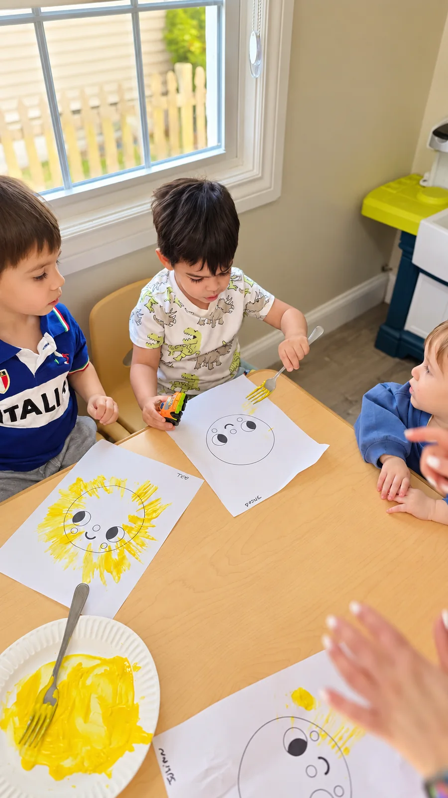 Children making sun paintings together with forks at the classroom table