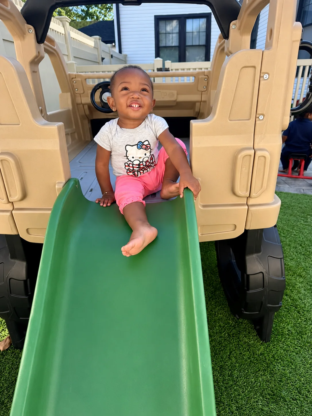 Smiling toddler enjoying the playground slide